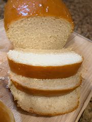 Sliced homemade white bread with a soft, fluffy texture and golden crust, freshly baked from scratch.