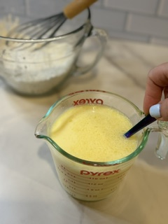 Wet ingredients being whisked together with a fork for homemade buttermilk pancakes