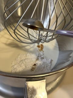 Heavy cream, powdered sugar, and vanilla extract in a large mixing bowl with whisk attachment, ready to whip into homemade whipped cream.