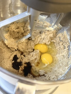 Wet ingredients for homemade chocolate chip cookies, including egg and vanilla, in a mixing bowl.