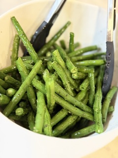 Fresh green beans bossed with olive oil, salt and pepper for roasting.