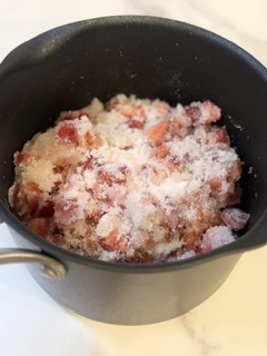 Fresh strawberries and sugar combined in a saucepan to make homemade strawberry jam